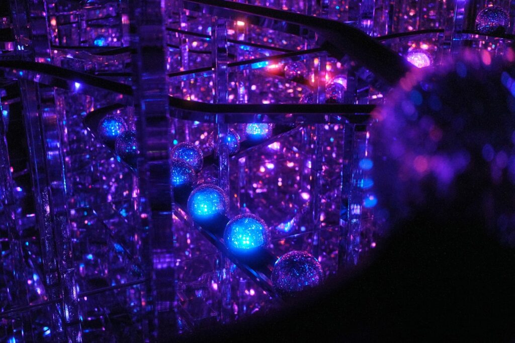 Abstract glowing spheres in a dark, reflective space.